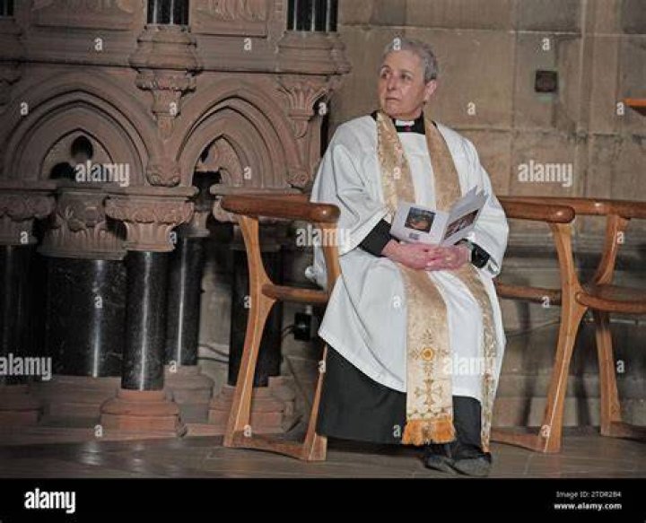 Happy: The Reverend Canon Marion De Quidt gestured to well-wishers as she stood under the stunning floral arch display at the venue just before celebrity guests began to arrive